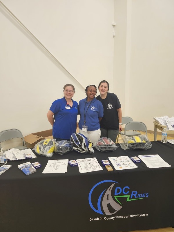 Three ladies standing behind a table.