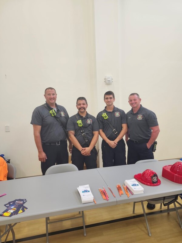 Four people standing behind a table.