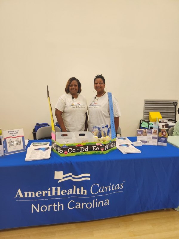 Two people standing behind a table.