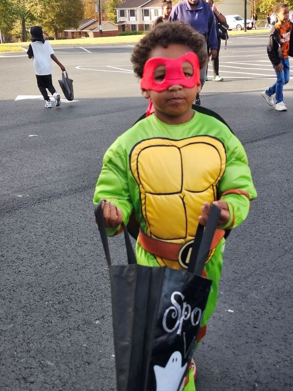 A boy in a ninja turtle costume.