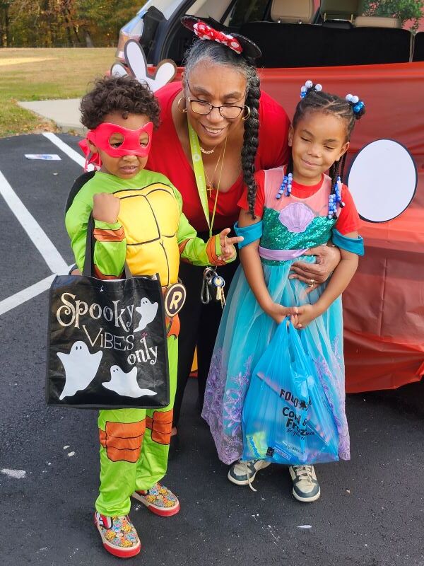 A woman posing with two kids in costumes.