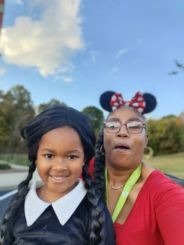 A woman posing with a girl in a costume.